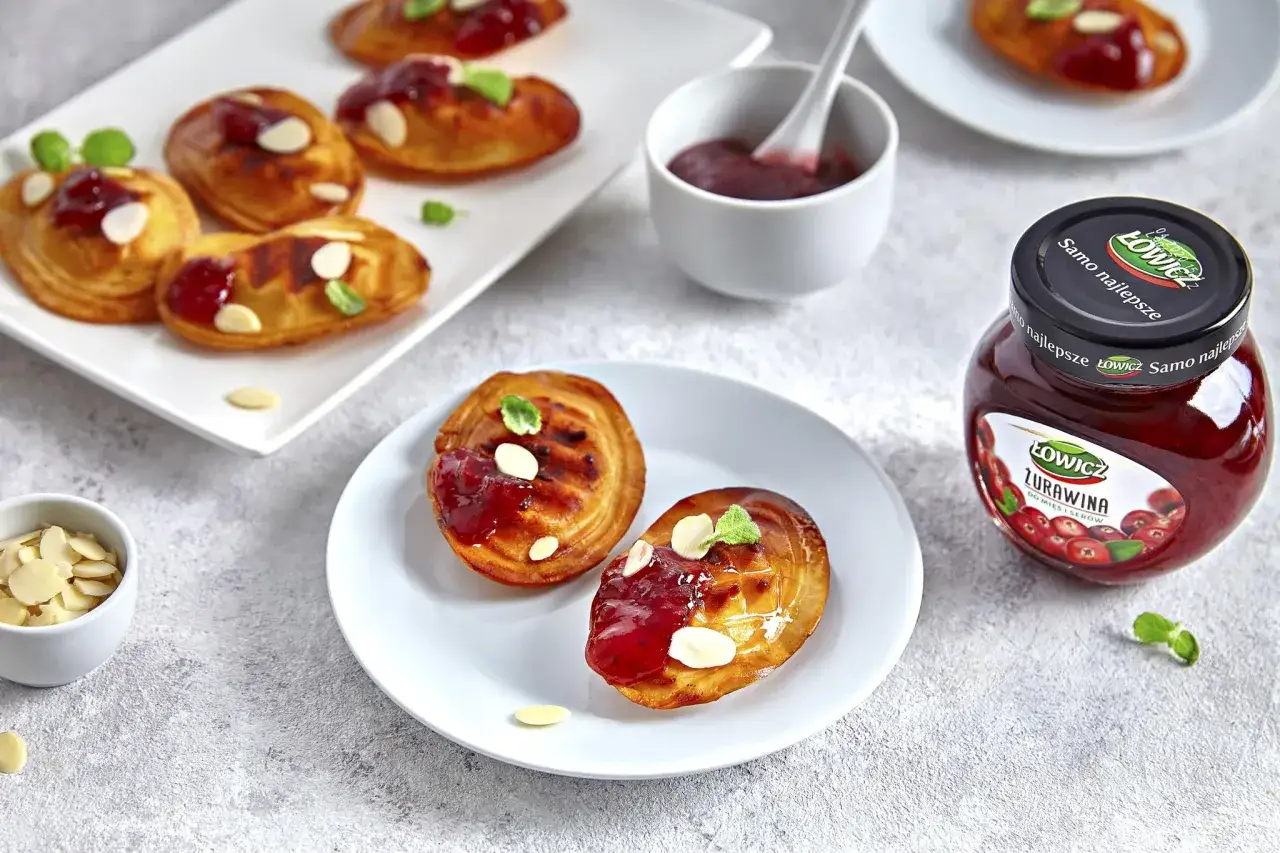 Oscypek z żurawiną, migdałami i miętą na talerzu.