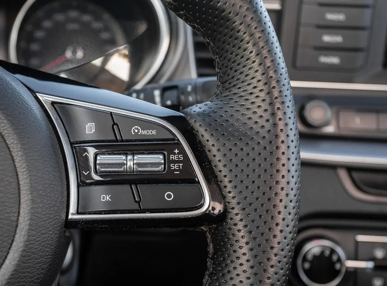Kierownica z perforowanej skóry, przyciski sterowania tempomatem. Zastanawiasz się, ile kosztuje obszycie kierownicy?