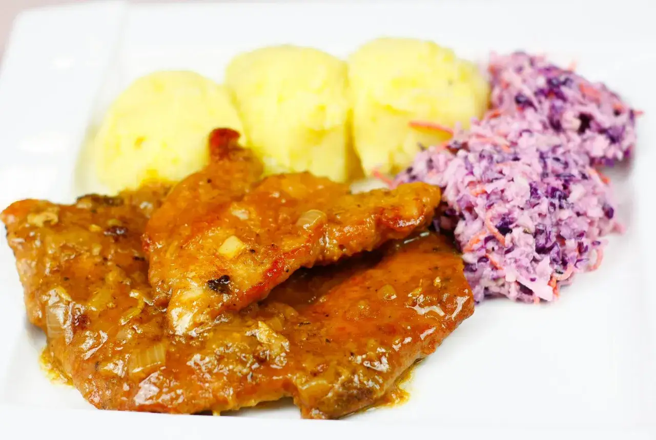 Biodrówka wieprzowa w sosie z ziemniakami i surówką z czerwonej kapusty – idealny pomysł, co zrobić z biodrówki wieprzowej na obiad.