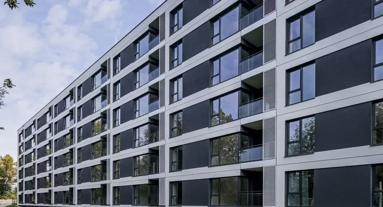 Nowoczesny blok mieszkalny z balkonami i dużymi oknami. Czy mieszkanie komunalne można wynająć w takim miejscu?
