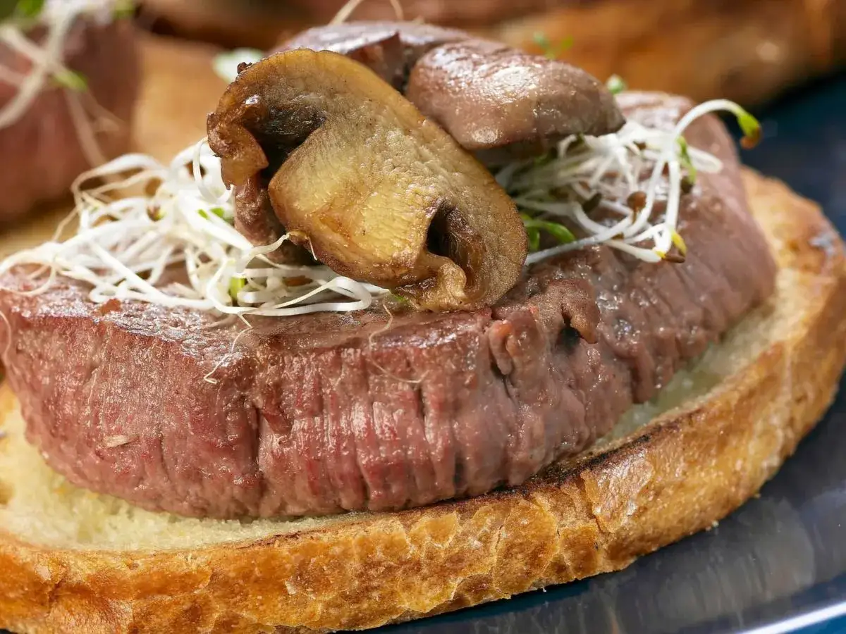 Twarda wołowina po ugotowaniu? Ten stek na grzance z grzybami i kiełkami pokazuje, jak uniknąć tego problemu.