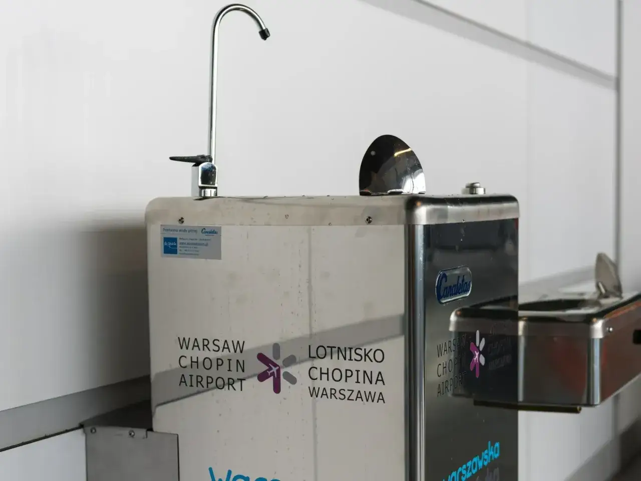 Fontanna z wodą na Lotnisku Chopina w Warszawie. Można tu uzupełnić butelkę, więc czy na lotnisku Chopina można wnieść wodę? Tak, można ją napełnić!