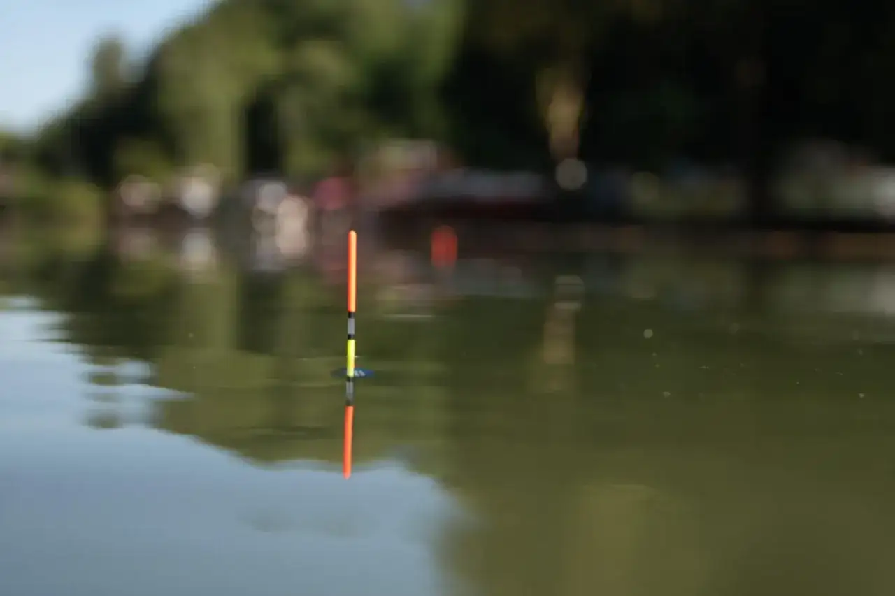 Pływak na wodzie, gotowy do łowienia. Dowiedz się, jak uzbroić wędkę na splawik, by cieszyć się wędkarską przygodą.