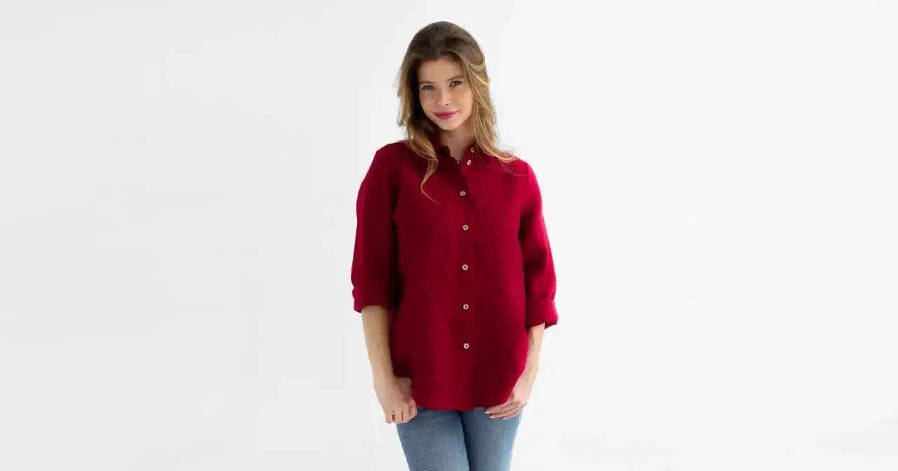 Kobieta w czerwonej koszuli i jeansach. Idealny zestaw, który pokazuje, co pasuje do czerwonej koszuli damskiej.
