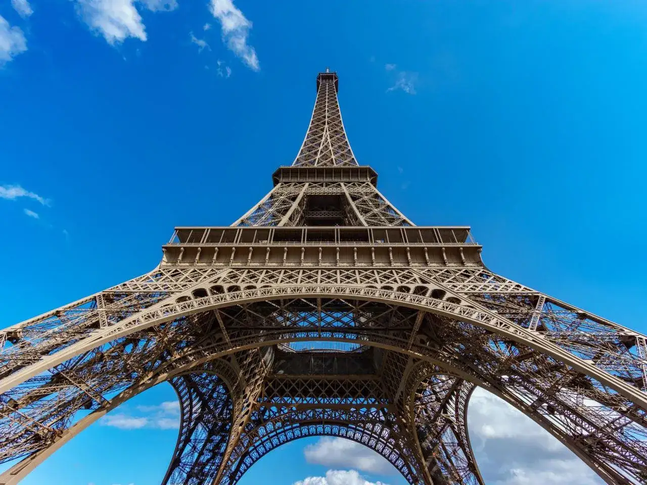Wieża Eiffla, symbol Paryża, wznosi się dumnie pod błękitnym niebem. Zastanawiasz się, ile lat ma Wieża Eiffla?