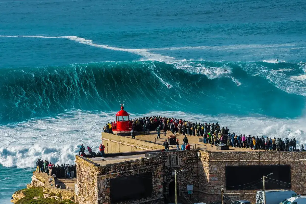 Tłum ludzi obserwuje surferów na gigantycznych falach Atlantyku. To dowód, że Portugalia ma dostęp do morza i to jaki!
