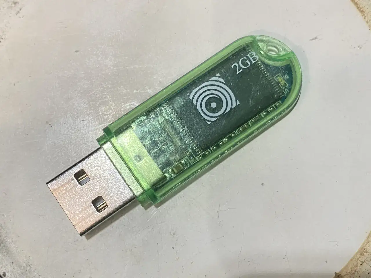 Zielony pendrive 2GB z widocznym chipem i logo.