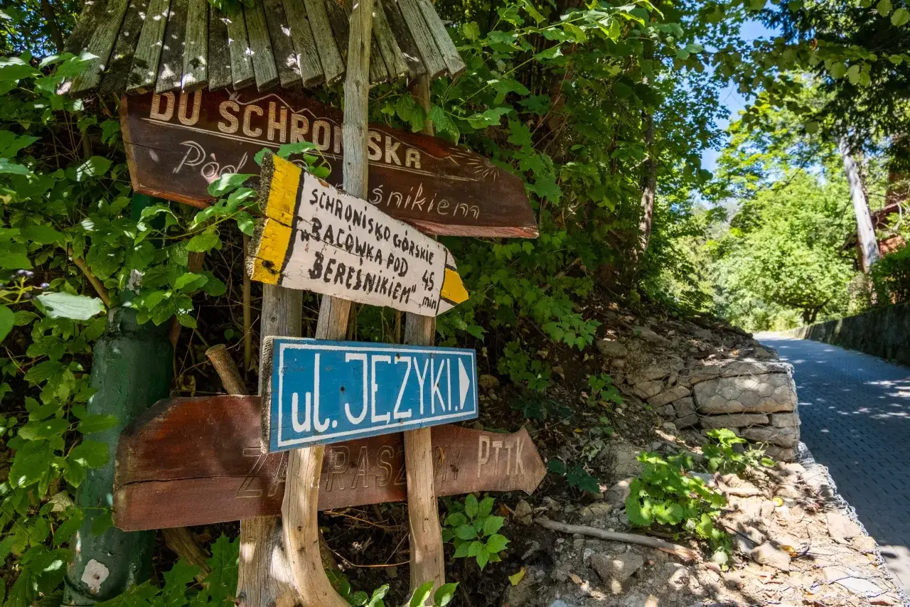 Drewniane drogowskazy wskazują drogę do schroniska górskiego Bacówka pod Beresnikiem. Sprawdź cennik i wybierz szlak!