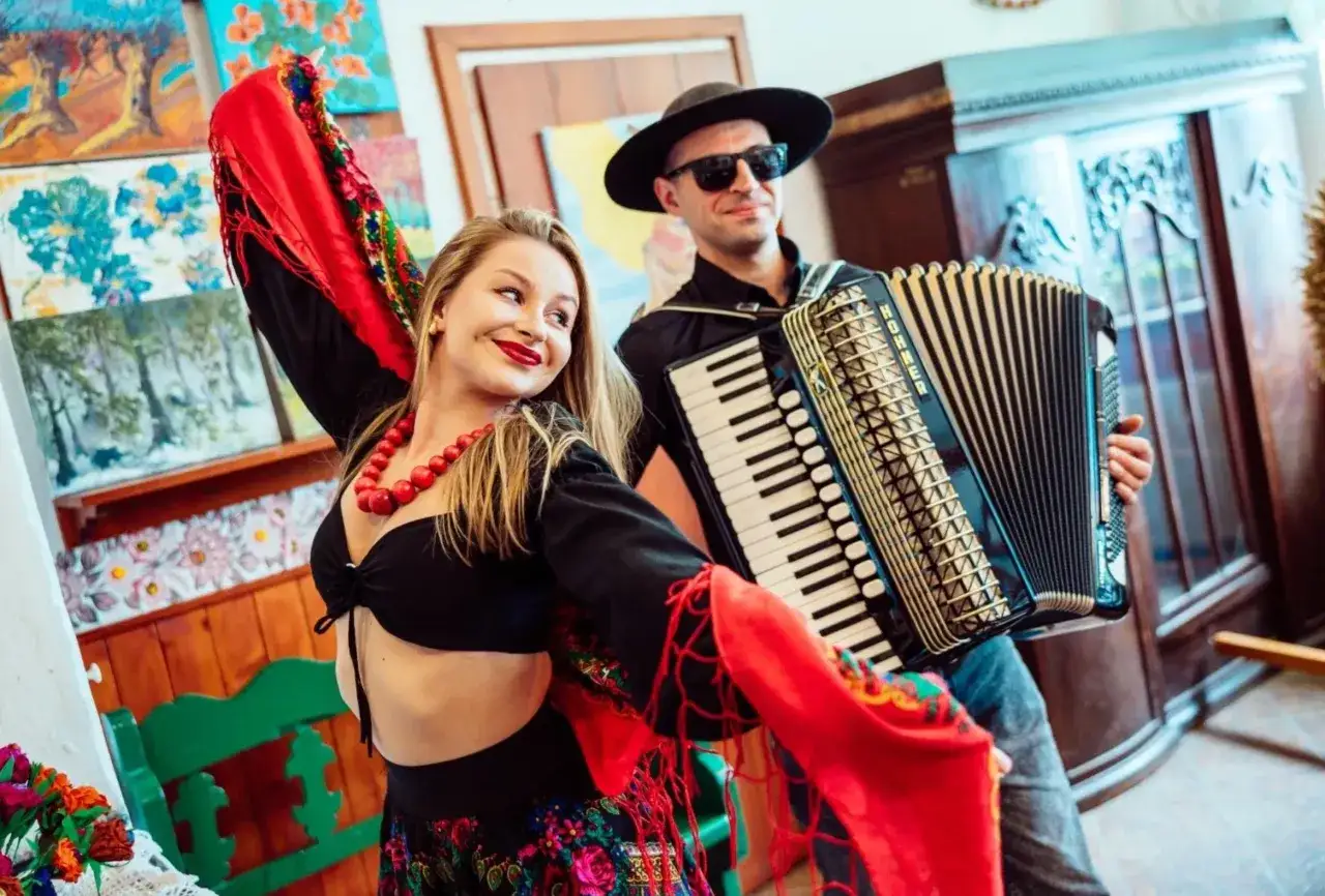 Zespół góralski disco polo w akcji! Wokalistka w barwnym stroju i akordeonista tworzą radosną atmosferę.