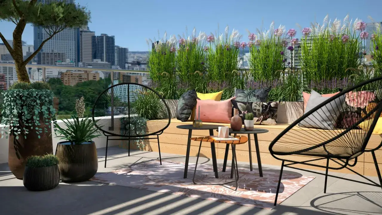 Mały taras przy domu z wygodnymi fotelami, stolikami i mnóstwem zieleni. Idealne miejsce na relaks z widokiem na miasto.