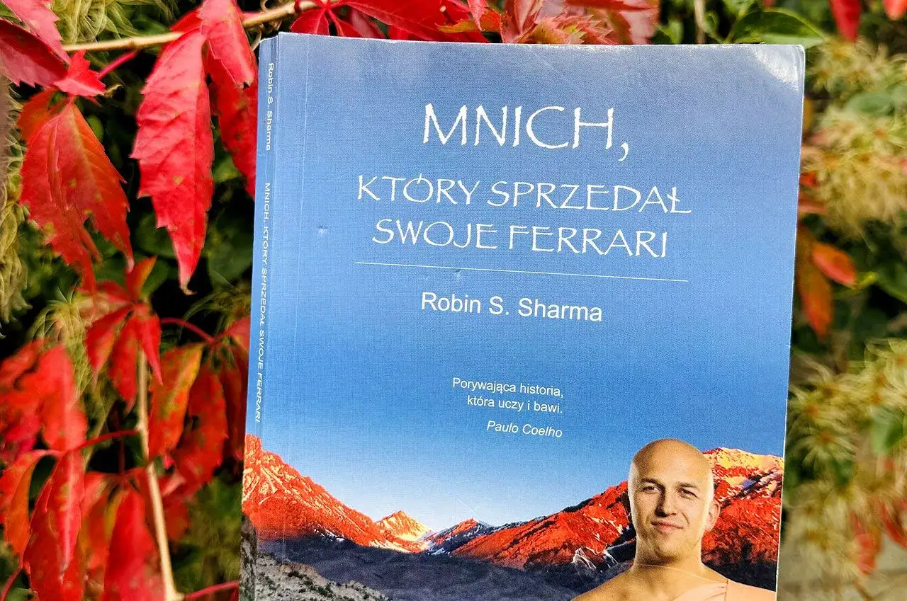 Okładka książki "Mnich, który sprzedał swoje Ferrari" Robina S. Sharmy na tle jesiennych liści.