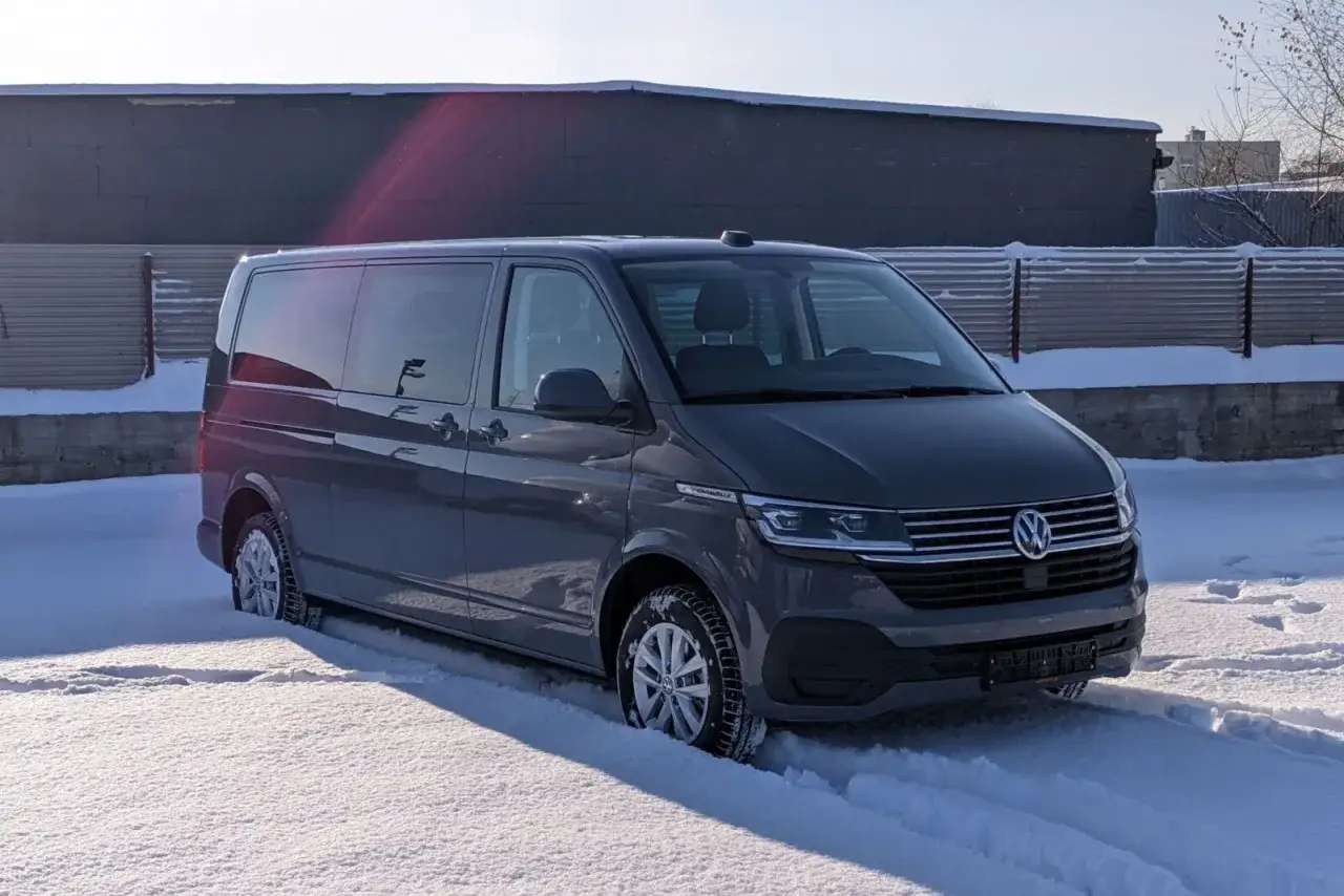 Szary bus 9-osobowy Volkswagen stoi na śniegu.
