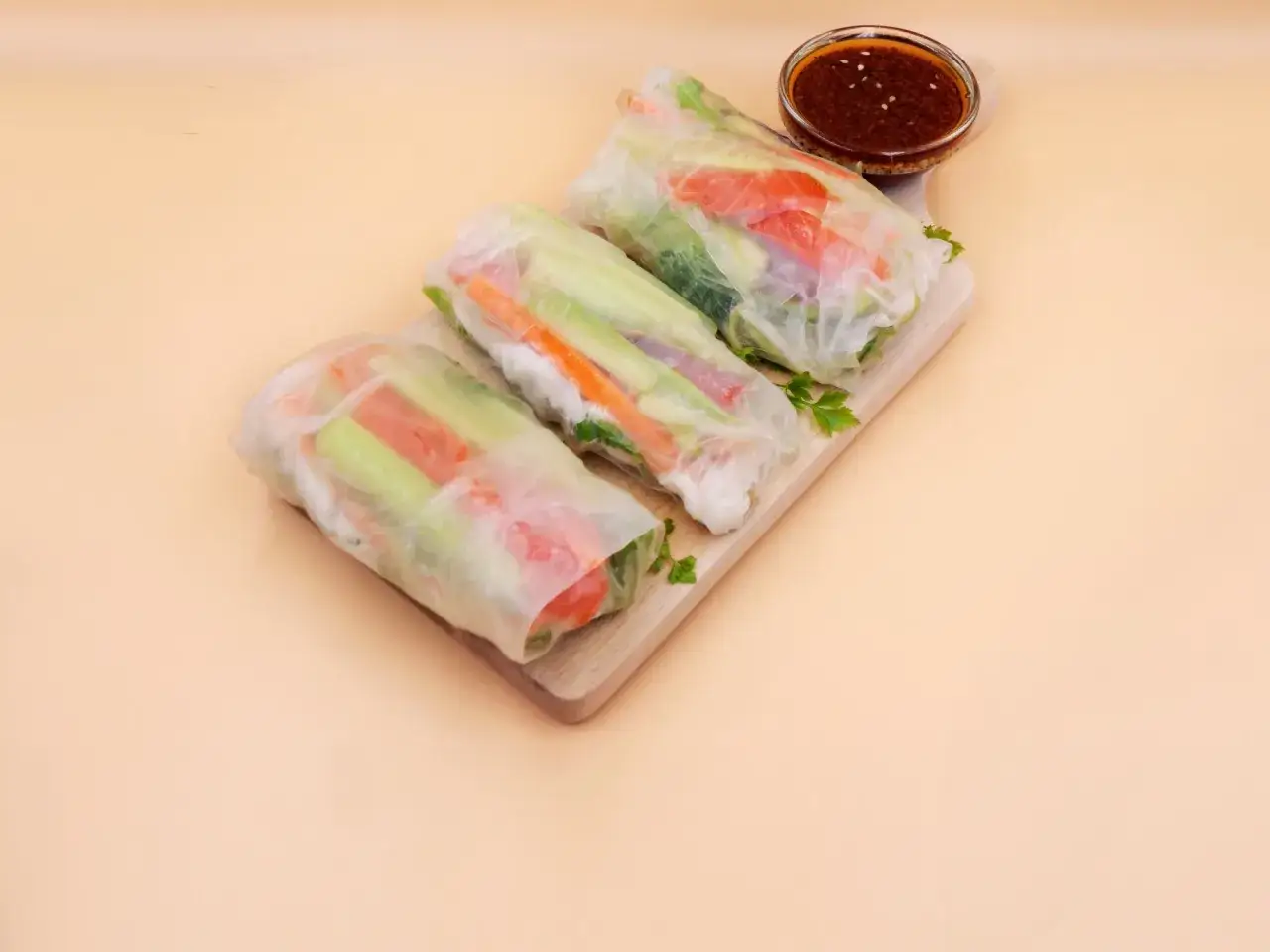 Trzy świeże rolki z łososiem i warzywami, podane z sosem. Idealne na lekki posiłek.