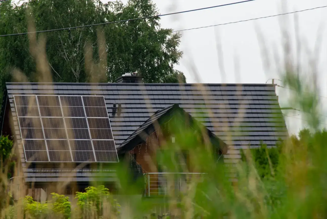 Dach domu z panelami fotowoltaicznymi, które wyglądają na instalację fotowoltaiczną bez zgłoszenia.