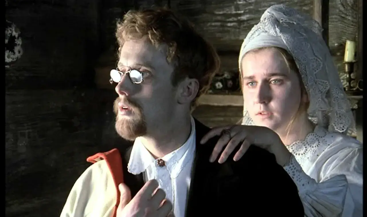 Mężczyzna w okularach i z brodą, przypominający imię Rydla poety, z kobietą w białej chuście.