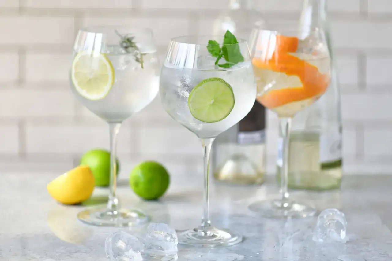 Orzeźwiający drink ze spritem, ozdobiony plasterkiem cytryny, limonki i skórką pomarańczy. Idealny na letnie popołudnie.