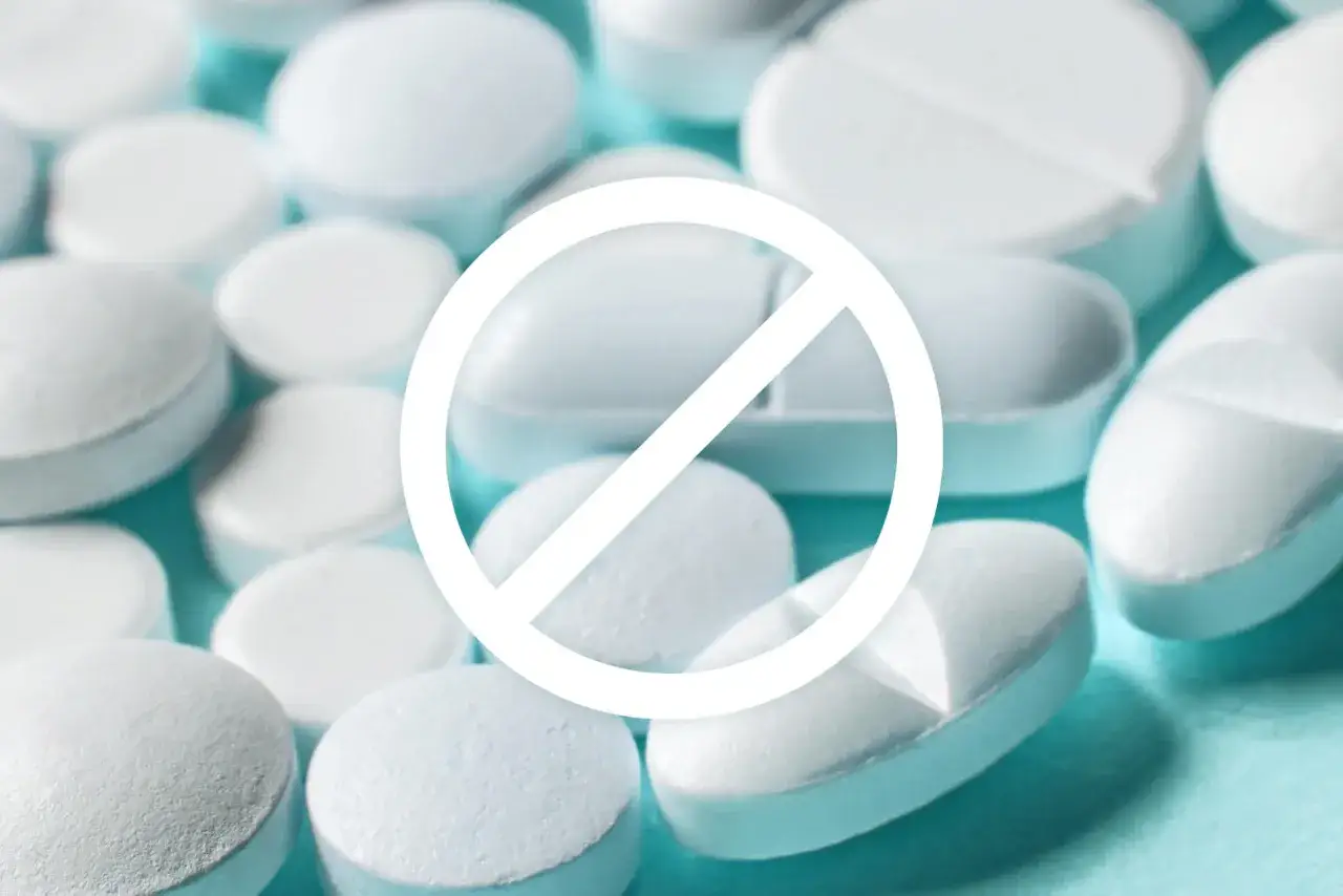 Białe tabletki i znak zakazu. Zrozum, dlaczego lekarze przepisują antybiotyki na wirusy, choć nie powinni.