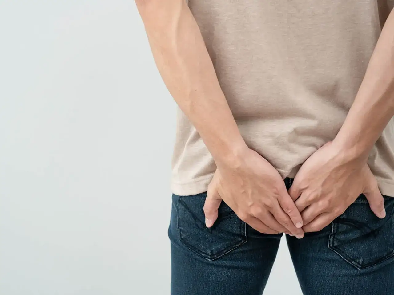 Osoba trzymająca się za pośladki, sugerująca problem z krwią z odbytu. Jaki lekarz może pomóc?