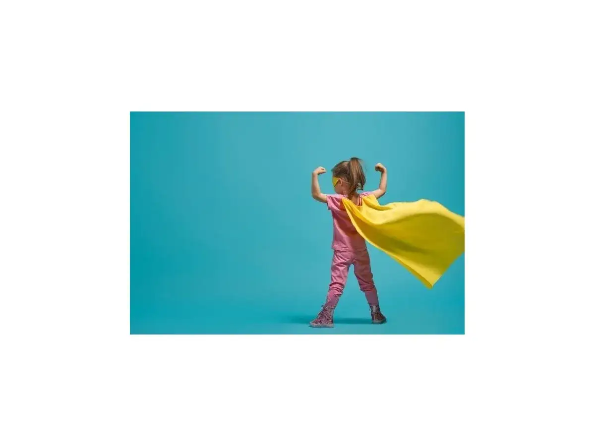 Mała dziewczynka w żółtej pelerynie i masce, dumna z własnoręcznie wykonanych przebrania dla dzieci do samodzielnego wykonania.