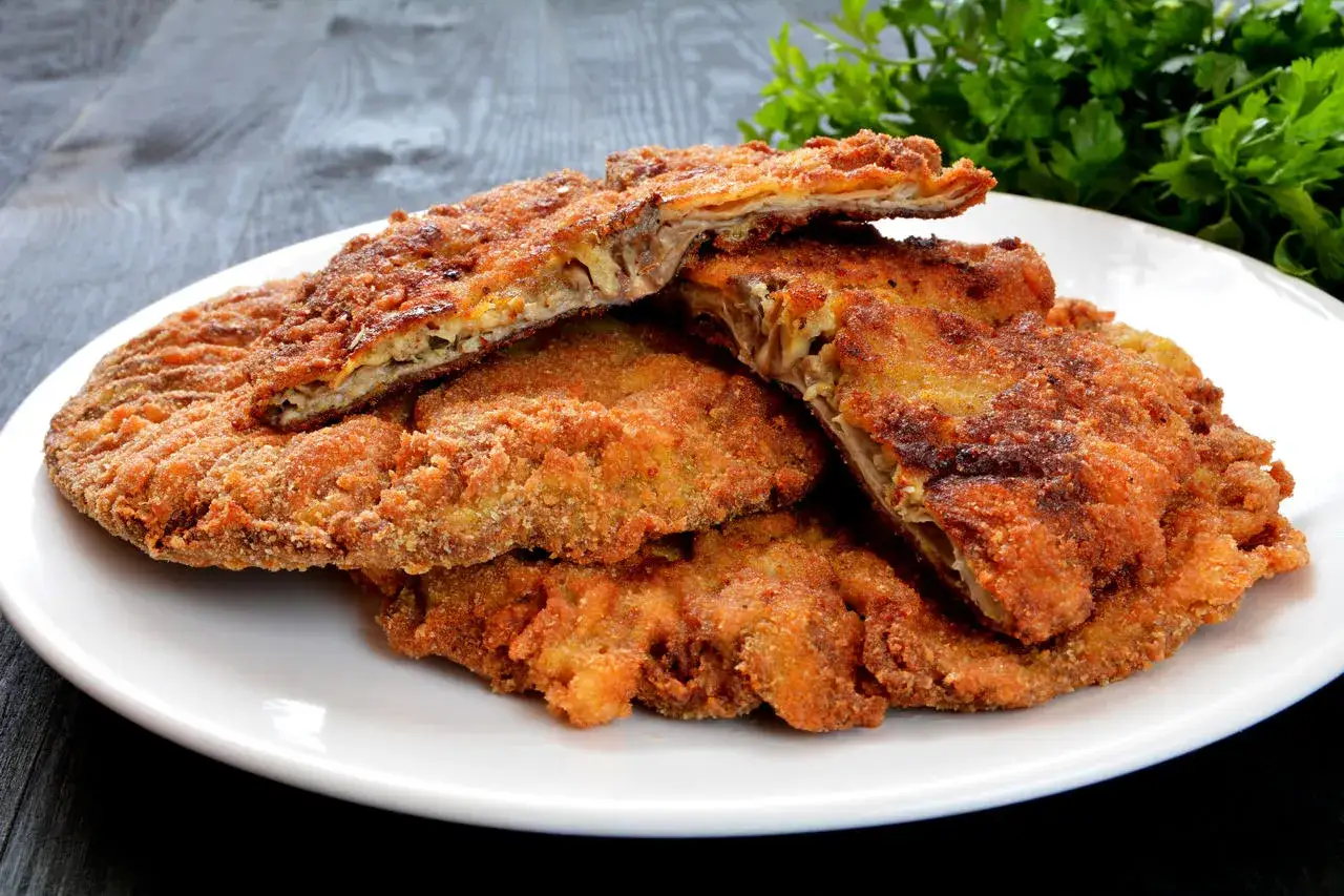 Złociste, panierowane kotlety z kani na talerzu. Idealne, gdy zastanawiasz się, jak smażyć mrożone kanie.