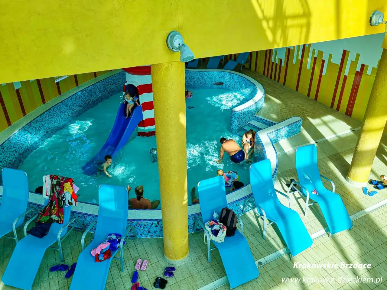 Dzieci bawią się w basenie zjeżdżalnią, a dorośli odpoczywają na leżakach. Czy to termy Bania czy Bukowina?