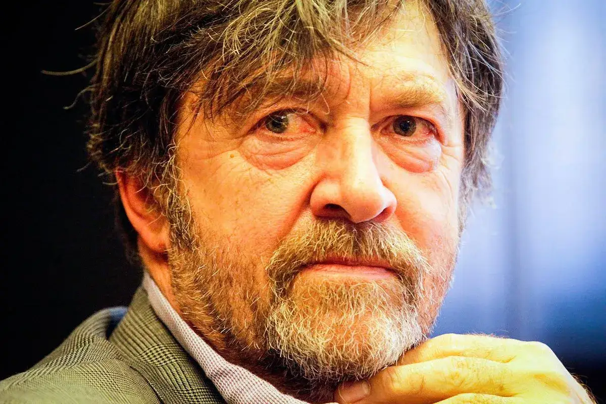 Zbliżenie na twarz Olek Krupa, z siwiejącą brodą i zmarszczkami wokół oczu.
