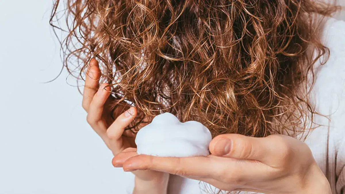Jak wybrać piankę do stylizacji włosów kręconych, aby uniknąć puszenia?