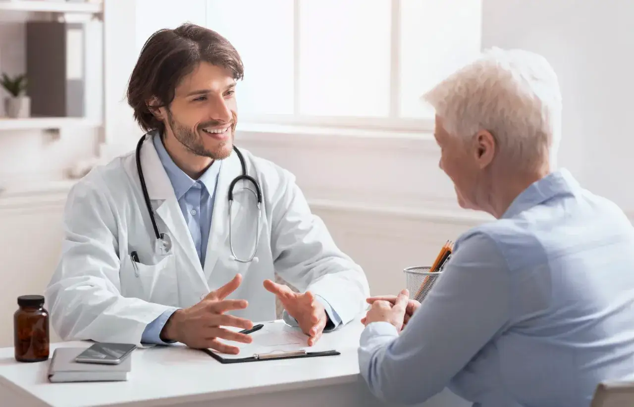 Lekarz wyjaśnia pacjentce, jak zmienić lekarza rodzinnego. Rozmowa w gabinecie lekarskim.