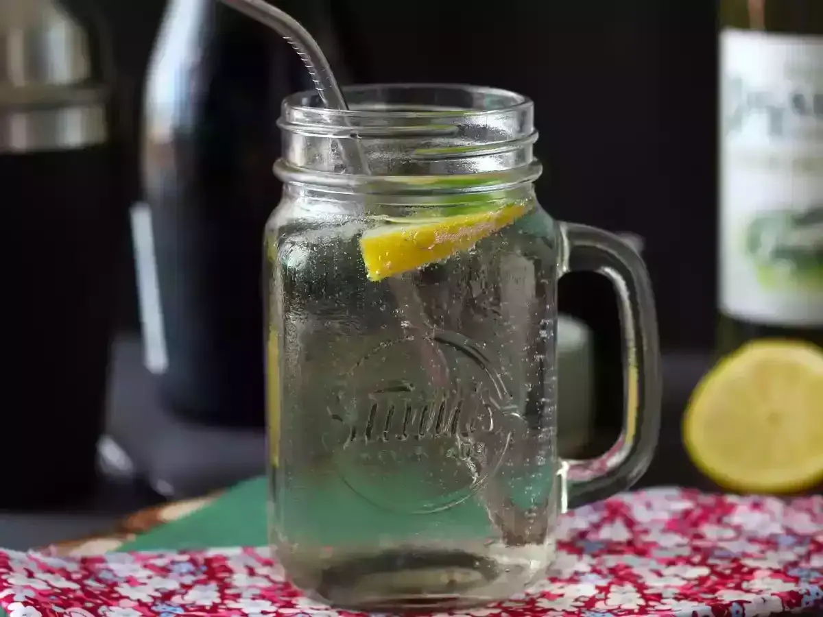Orzeźwiający Hugo Spritz w słoiku z cytryną i miętą, gotowy do wypicia.