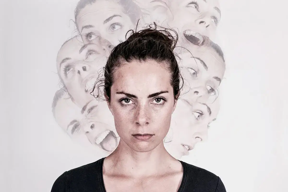 Kobieta z wieloma twarzami wyrażającymi różne emocje, na jasnym tle.
