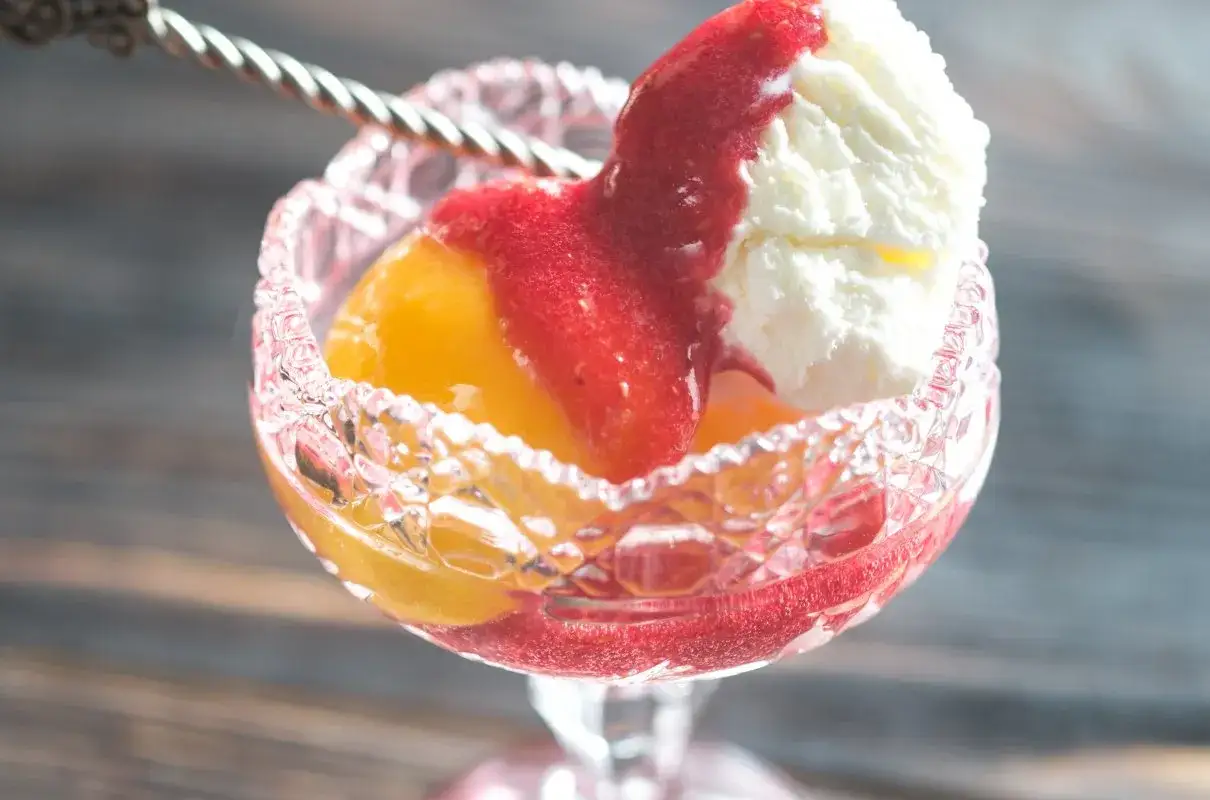 Pyszny deser z brzoskwiniami, lodami waniliowymi i sosem truskawkowym. Idealny na lato, prosty Melba przepis.