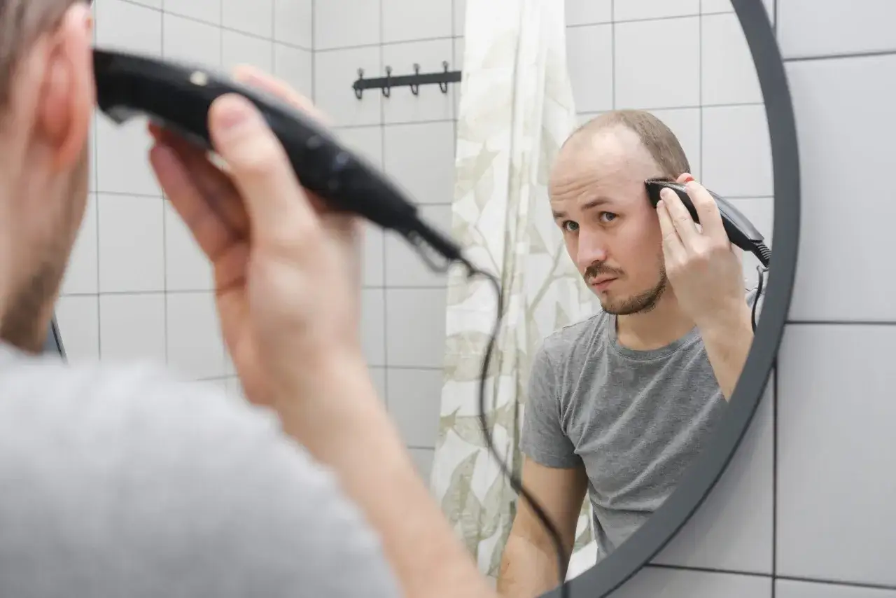 Mężczyzna goli głowę na łyso, używając najlepszej maszynki do golenia.