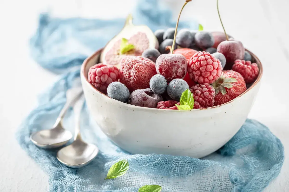 Mrożone owoce w misce: maliny, borówki, truskawki, wiśnie i figa. Czy mrożone owoce trzeba myć? Zależy od sposobu ich przygotowania.