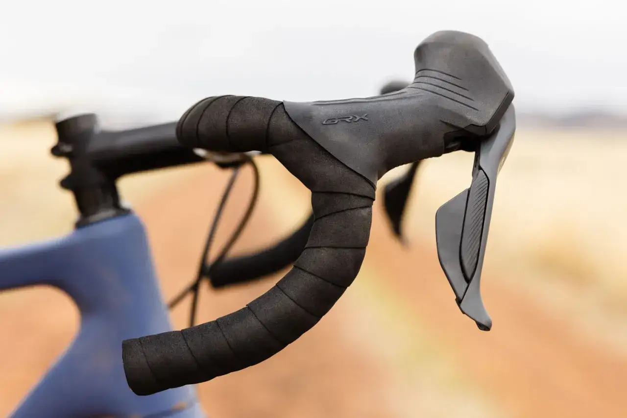 Kierownica gravelowa z owijką i manetkami Shimano GRX, gotowa na przygodę.