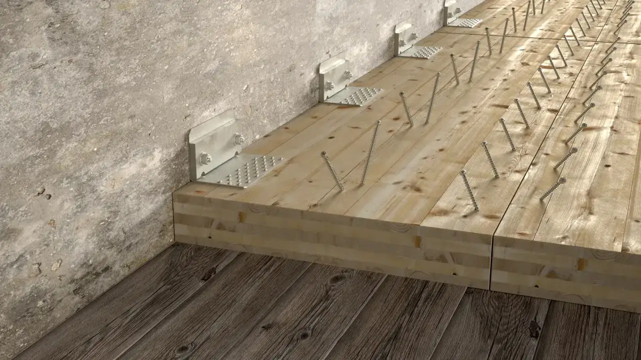 Wzmocnienie stropu od góry: drewniane belki połączone z betonową ścianą metalowymi kątownikami i licznymi wkrętami.