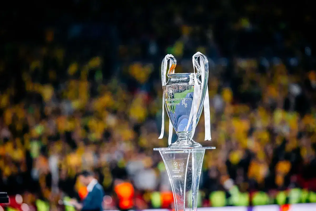 Trofeum Ligi Mistrzów na podium, z tłumem kibiców w tle. Zastanawiasz się, ile za wygranie ligi mistrzów?
