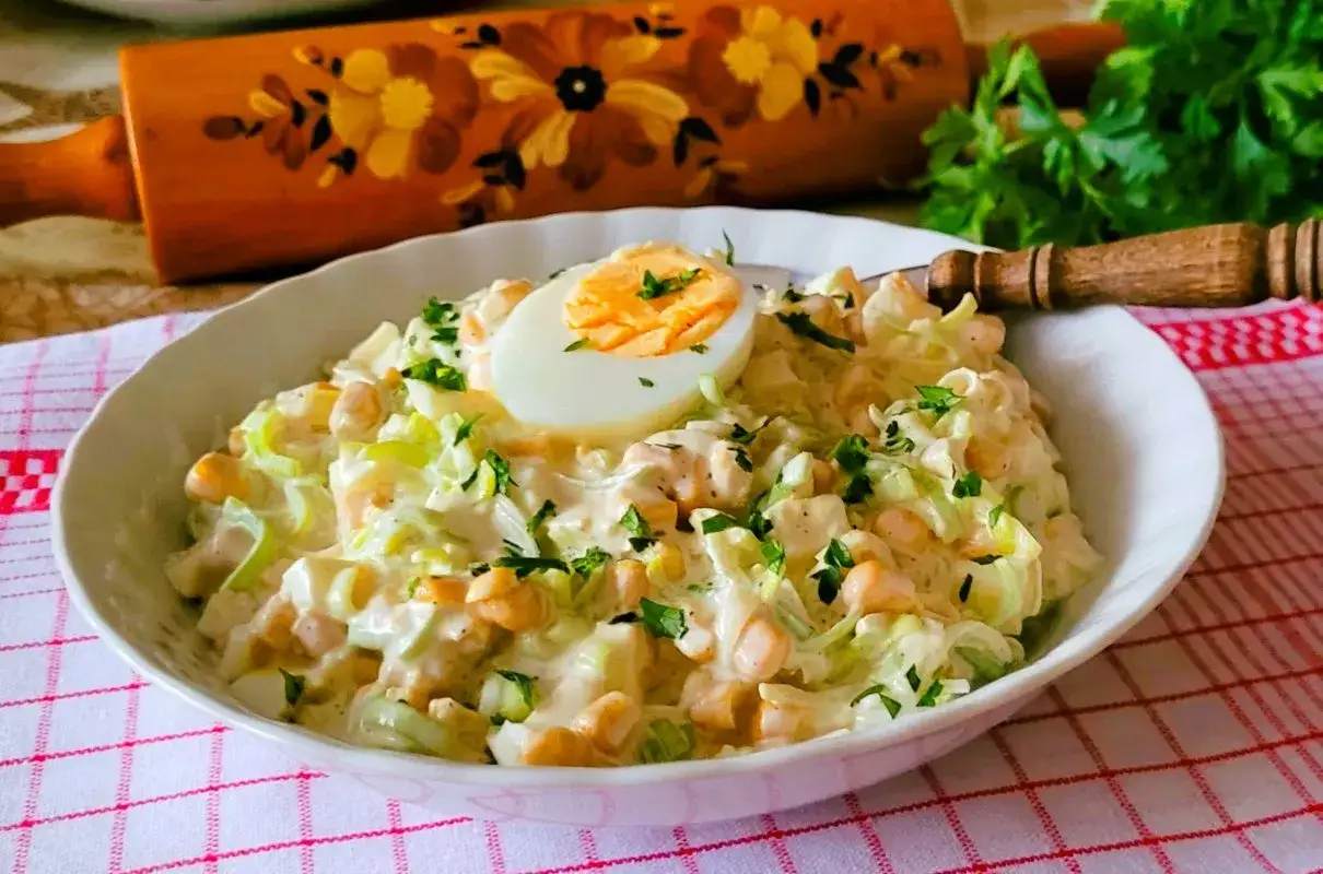 Pyszna, kremowa sałatka porowa z jajkiem i kukurydzą, posypana natką pietruszki. To najlepsza sałatka porowa na każdą okazję!