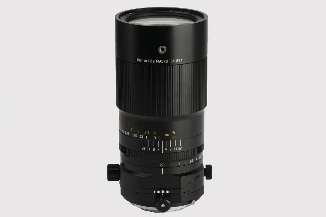 Czarny obiektyw makro 100mm f/2.8 z oznaczeniami odległości i przysłony.