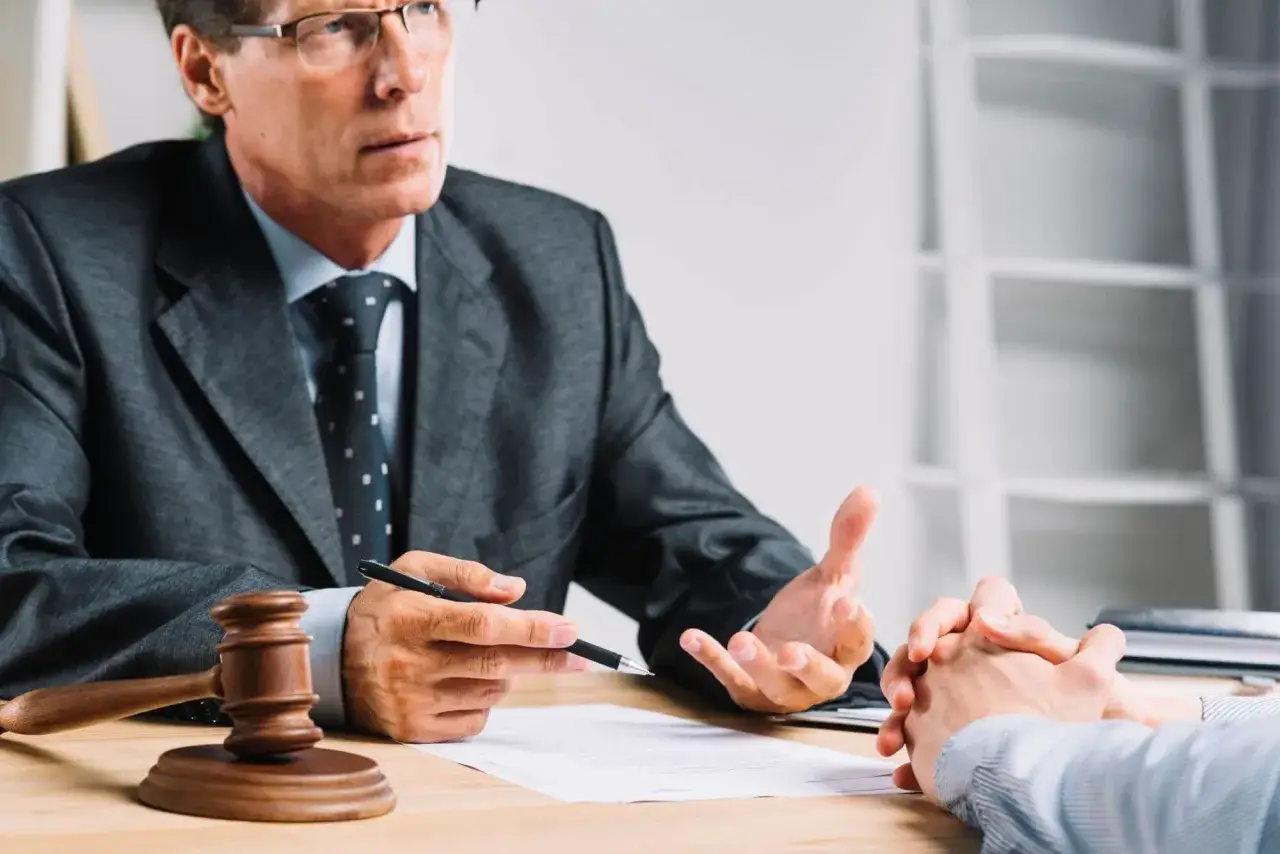 Prawnik wyjaśnia, czy można zwolnić pracownika na świadczeniu rehabilitacyjnym. Na stole młotek sędziowski.