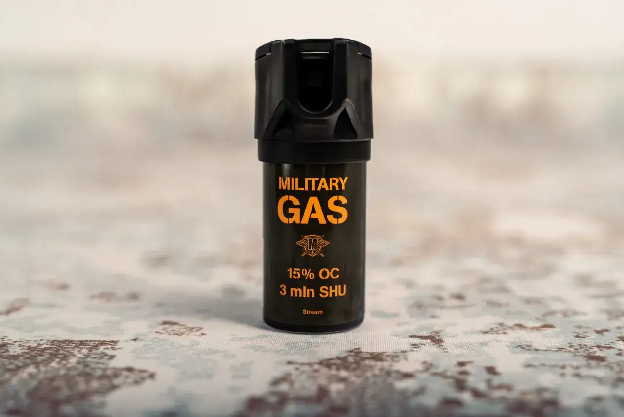 Czarny gaz pieprzowy z pomarańczowym napisem "MILITARY GAS" i informacją "Stream".