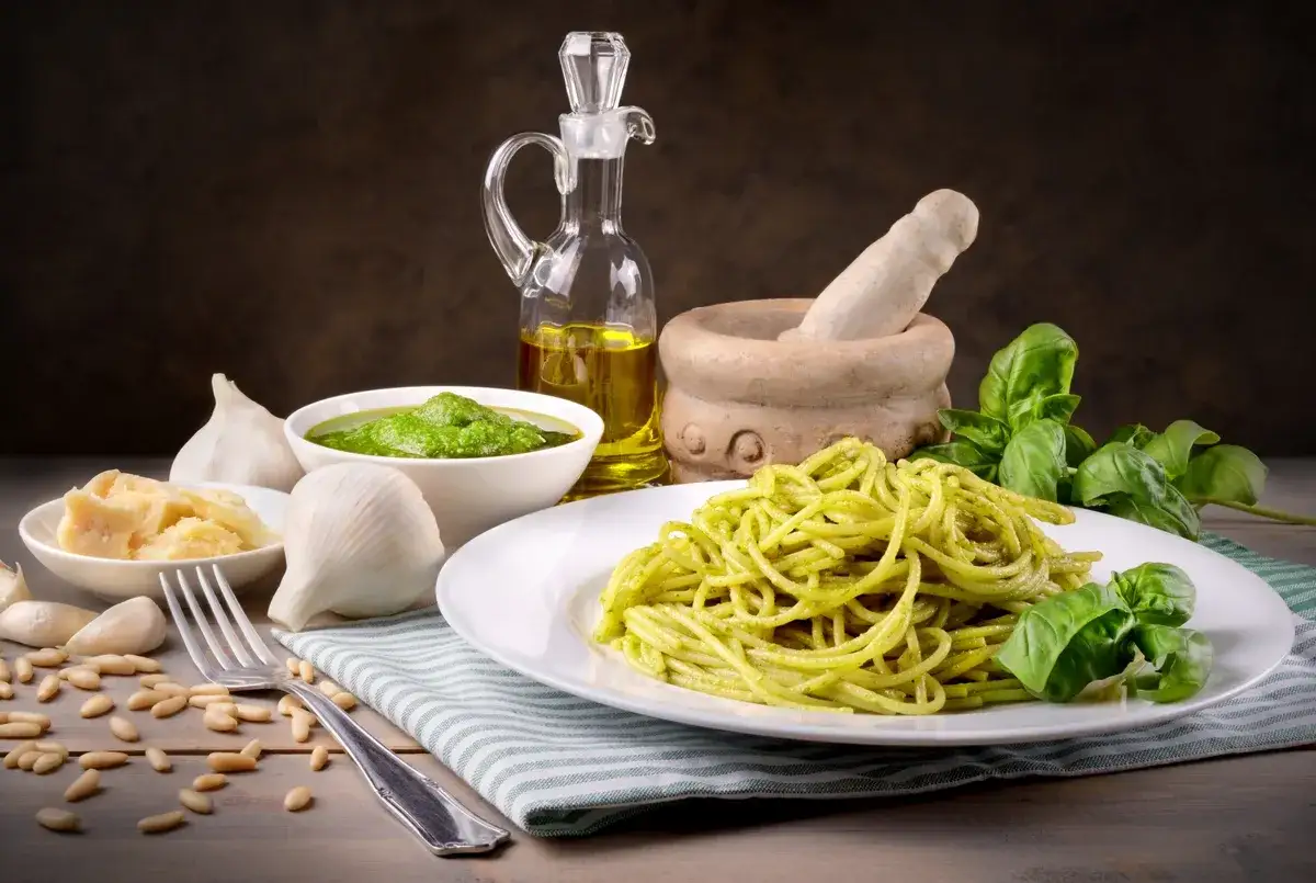 Pyszny makaron z pesto ze słoika, podany z bazylią, czosnkiem, parmezanem i orzeszkami pinii.