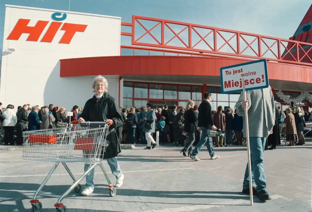 Klienci przed wejściem do sieci francuskich hipermarketów HIT. Jedna osoba trzyma tabliczkę "Tu jest wolne Miejsce!".