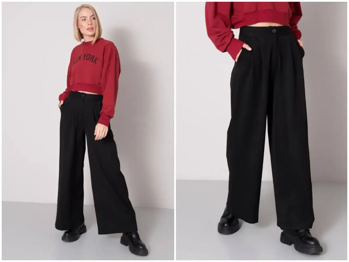 Kobieta w bordowej bluzie z napisem "New York" i czarne szerokie spodnie stylizacje.