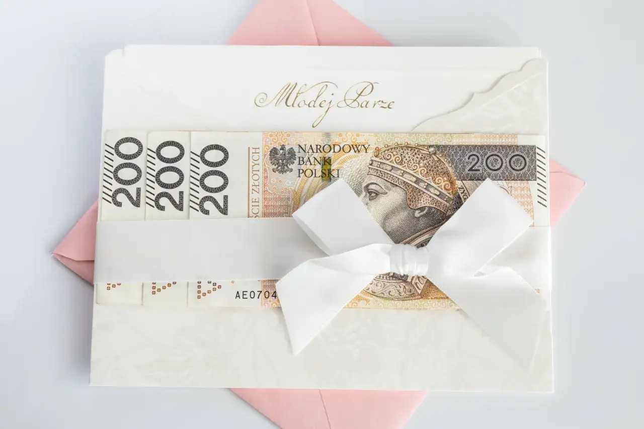 Elegancka koperta z napisem "Młodej Parze", ozdobiona banknotami 200 zł i białą wstążką. Idealny sposób, jak udokumentować pieniądze z wesela.