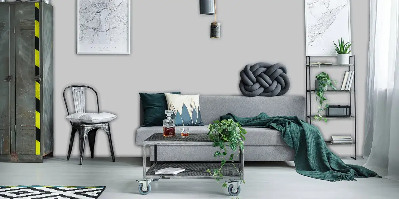 Nowoczesny salon z szarą sofą, metalowym fotelem i stolikiem. W tle industrialna szafa i regał. Kolory kojarzą się z szarym pirytem lub srebrzystym granitem.