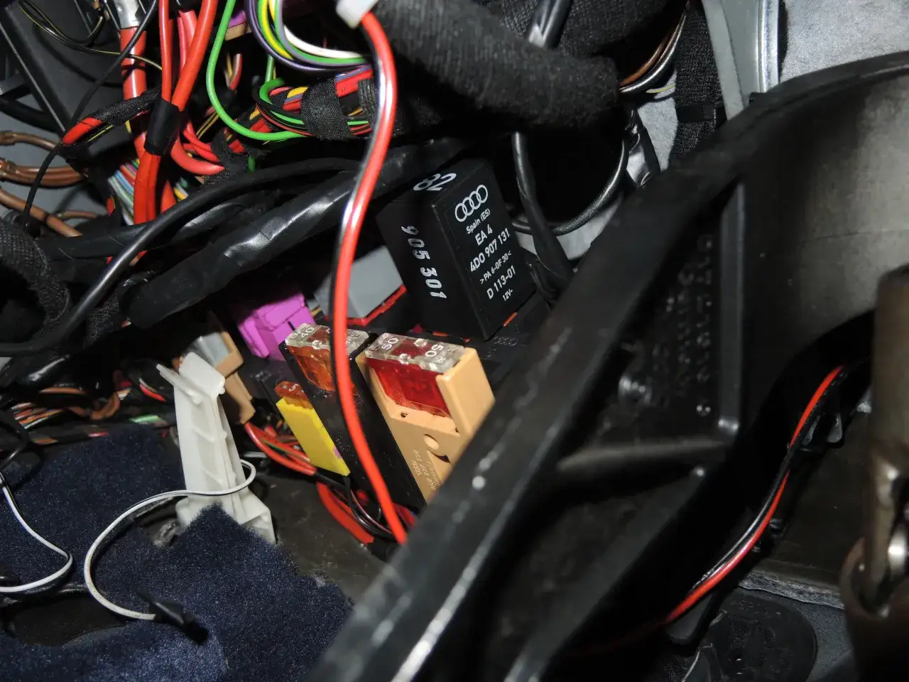 Pompka centralnego zamka Audi A4 B5 znajduje się w wiązce przewodów pod deską rozdzielczą, obok bezpieczników.