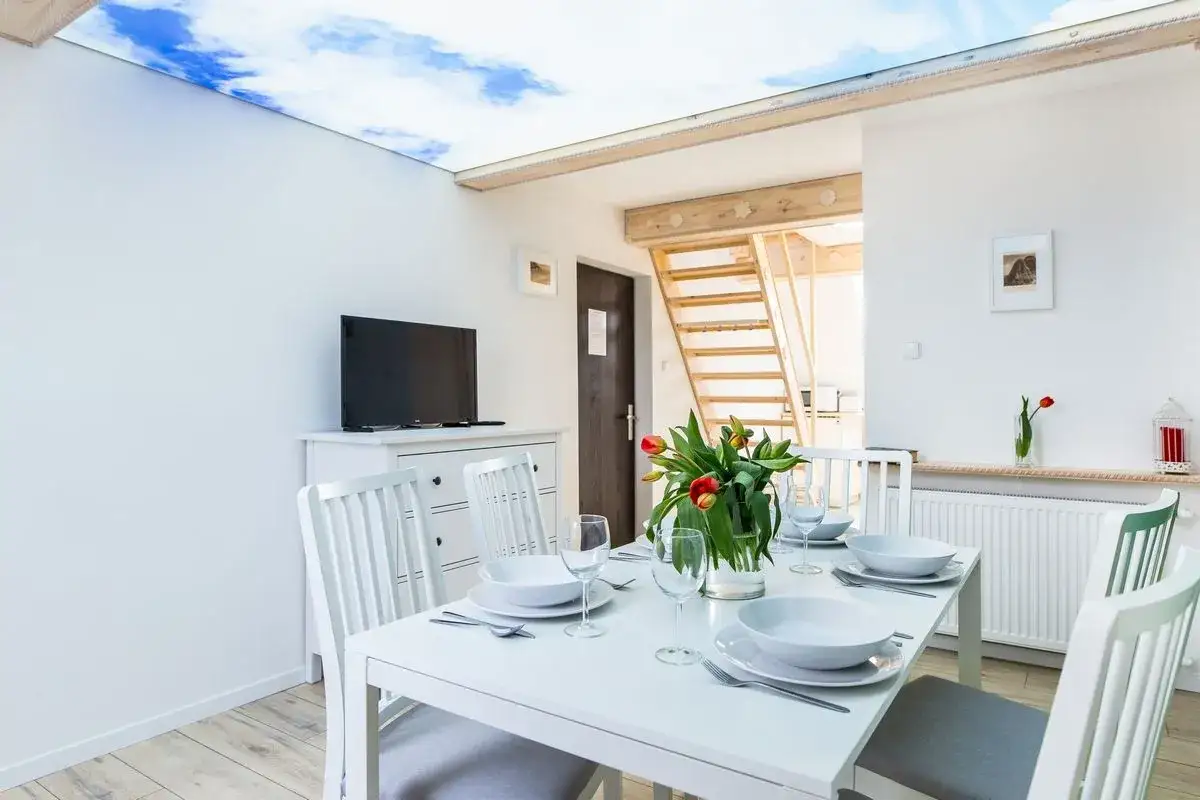 Stół z tulipanami i nakryciami czeka na gości w przytulnej jadalni. Nad głowami rozpościera się niebo, jak w limba bukowina tatrzańska.