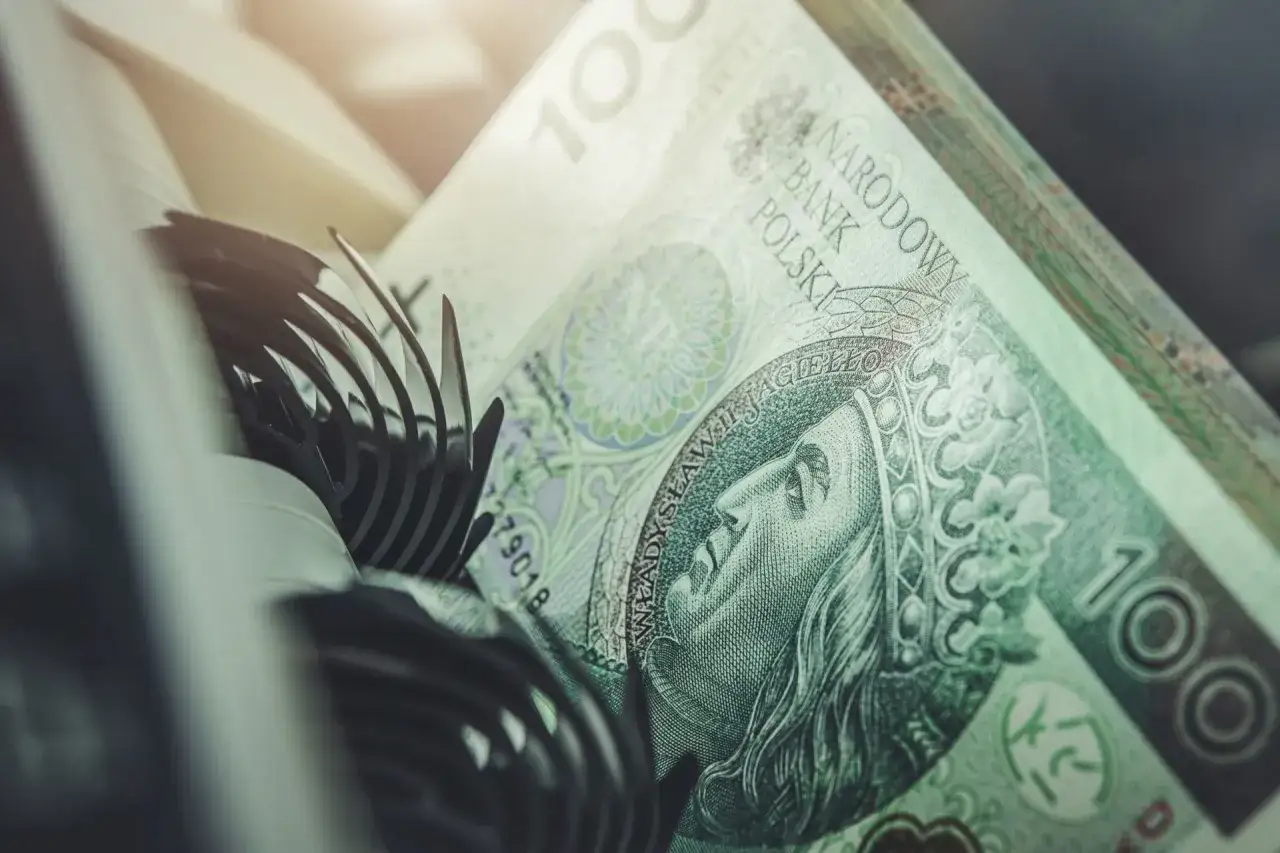 Stos banknotów 100 zł, część mechanizmu maszyny liczącej. Szybkie vivus przelewy w nocy.