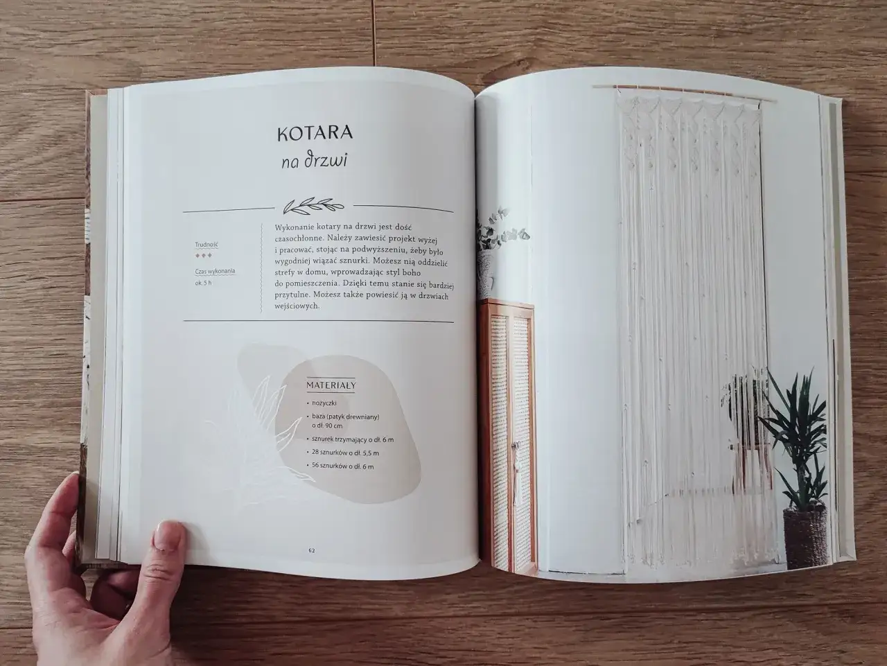 Książka z instrukcją wykonania makramy na drzwi. Na stronie po prawej widać gotową, wiszącą makramę.