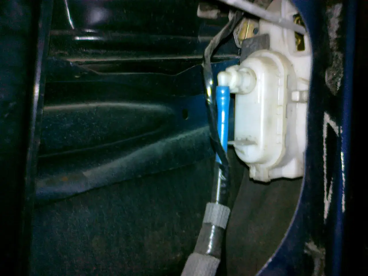 Mechanizm zamka w drzwiach VW Polo. Widoczny siłownik i przewody, pomocne przy pytaniu jak zamontować centralny zamek VW Polo.